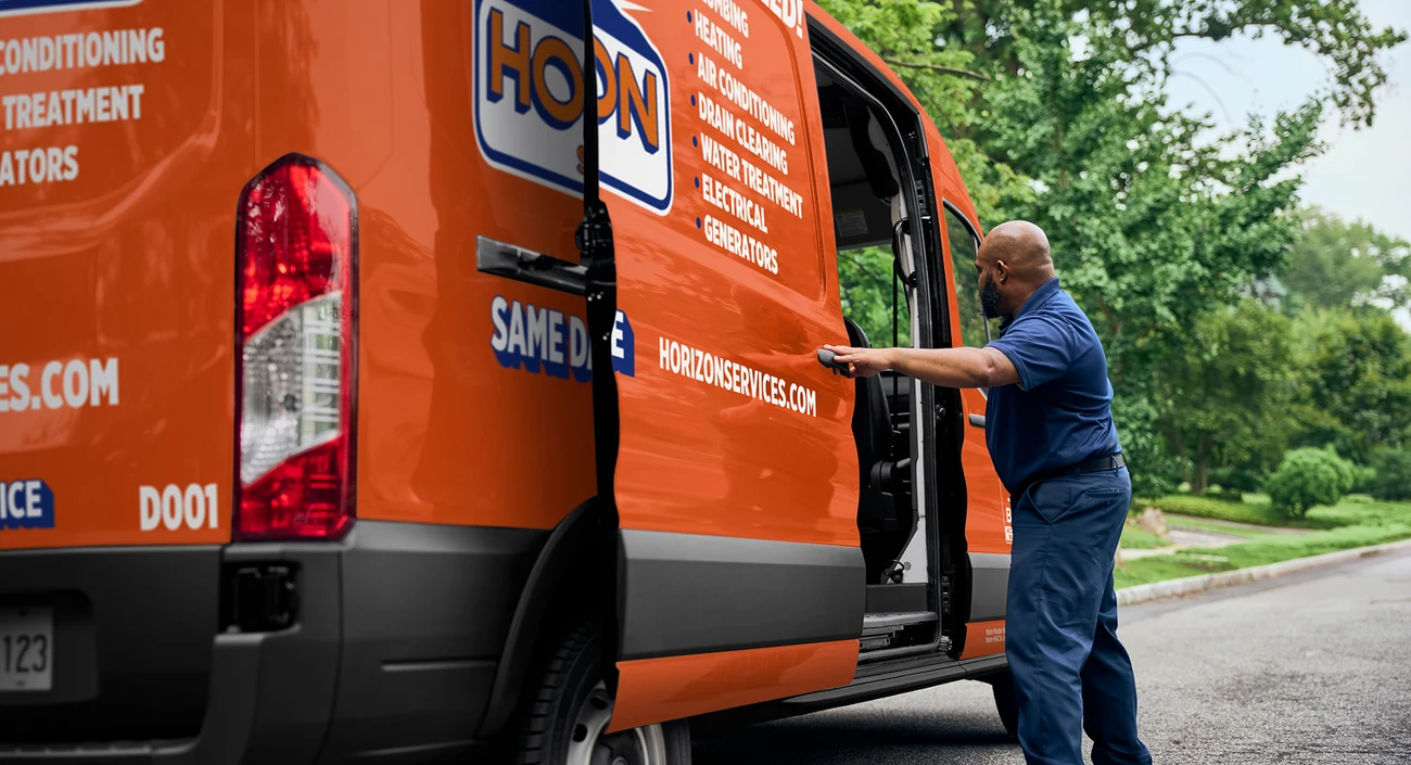 Horizon service technician preparing an orange service van for a home visit